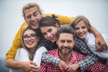 Bir grup mutlu insan. Gülümseyen arkadaşlar başparmakla gülüyorlar. Şirket öğrencileri selfie çeken en iyi arkadaşlar. Grup gençleri birlikte poz veriyor. Çok ırklı iş adamları.
