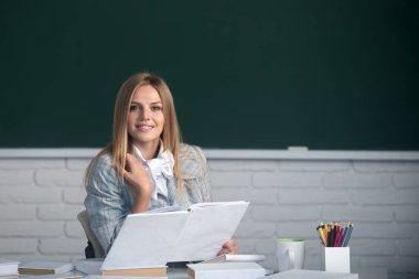 Sınava hazırlanan, elinde kitap tutan ve okuyan kız üniversite öğrencisi..