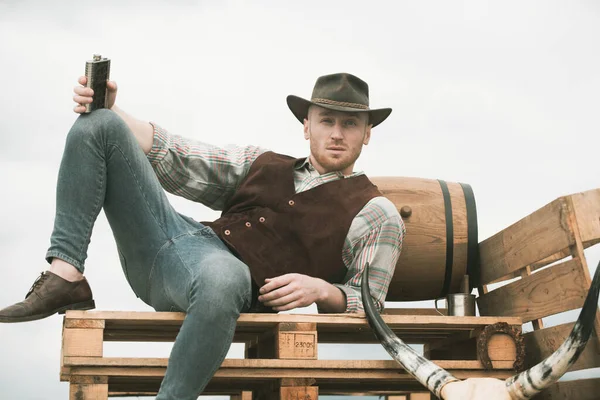 American cowboy man. Handsome brutal western guy. Attractive man with whiskey or brandy. — Stock Photo, Image