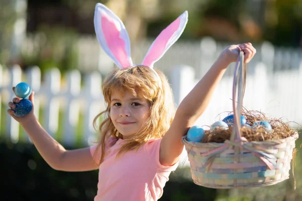 Niña emocionada con canasta de Pascua. Conejito de Pascua niño con cara linda. Niños cazando huevos de Pascua. Felices fiestas de Pascua. —  Fotos de Stock