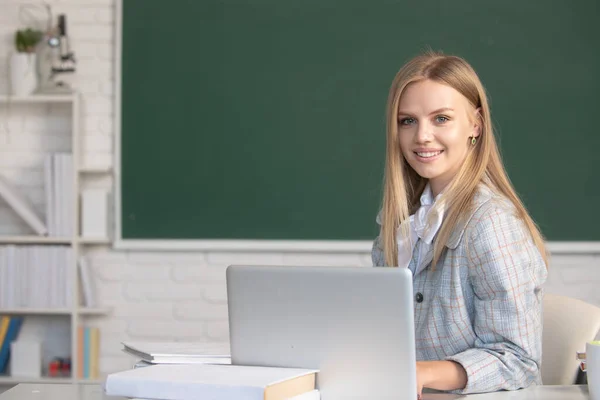 Sevimli bir genç kız, okul öğrencisi notlar yazar, internetten video izler, dizüstü bilgisayarda öğrenir, sınıfta oturur, uzaktan öğrenme kursuna gider.. — Stok fotoğraf