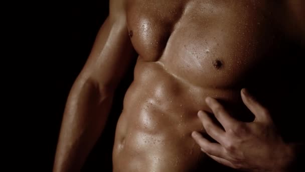 Hombre atlético fuerte mostrando cuerpo musculoso y seis abdominales sobre fondo negro. Fuerte atlético modelo de fitness hombre que muestra seis abdominales paquete. Pecho masculino desnudo aislado sobre fondo negro. — Vídeos de Stock