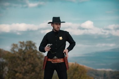 Şerif ya da şerif. Kovboyla vahşi batı. Dışarıda silahlı, ciddi bir adam var..