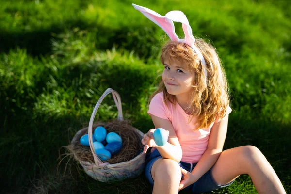 Wielkanocne dzieci. Szczęśliwej Wielkanocy. Dzieci w króliczych uszach z jajkiem wielkanocnym w koszyku. Chłopiec bawić się w polowanie jaj. — Zdjęcie stockowe