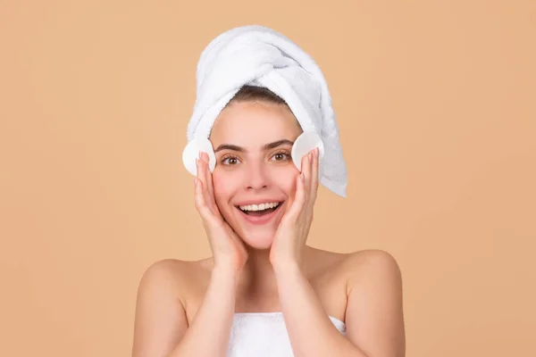 Retrato de cara de belleza. Terapia de spa, hermosa mujer en toalla tocando mejilla con esponja cuida de la piel. — Foto de Stock