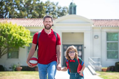 Açık hava okulu. Baba ve oğul okuldan dönüyorlar. Okul, aile, eğitim ve açık hava konsepti.