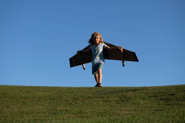 子供の男の子は夏休みと旅行について遊んで夢を見ています。子供の想像力と自由の概念。ハッピー子供遊びとともにおもちゃの飛行機に対して青い夏の空の背景. — ストック写真