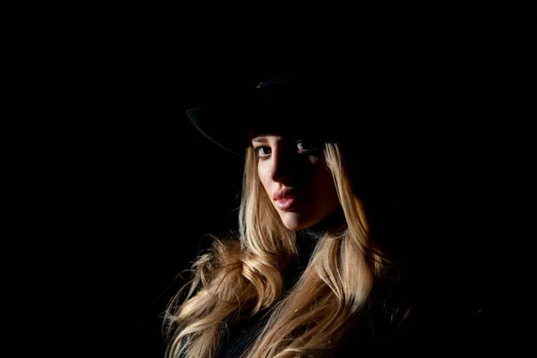 Σέξι πανέμορφη γυναίκα με σκιές σε όμορφο πρόσωπο και καπέλο μόδας σε μαύρο στούντιο. Μόδα πορτρέτο της όμορφης γυναίκας με σκούρο φως στο πρόσωπο. — Φωτογραφία Αρχείου