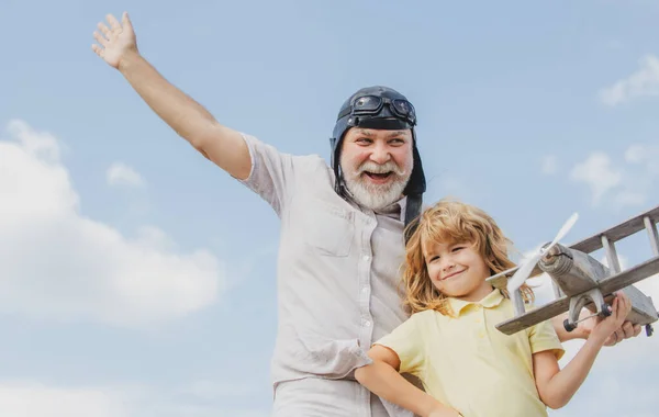 Grand-père et petit-fils jouant avec l'avion jouet sur fond de ciel d'été. — Photo