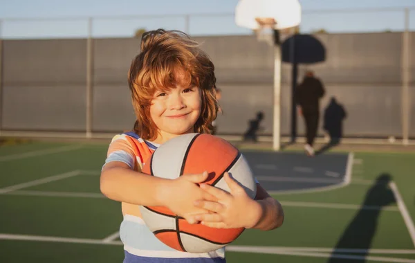 Menino feliz jogando basquete no playground. — Fotografia de Stock