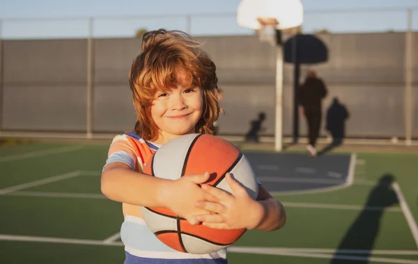 Ragazzino felice che gioca a basket nel parco giochi. — Foto Stock