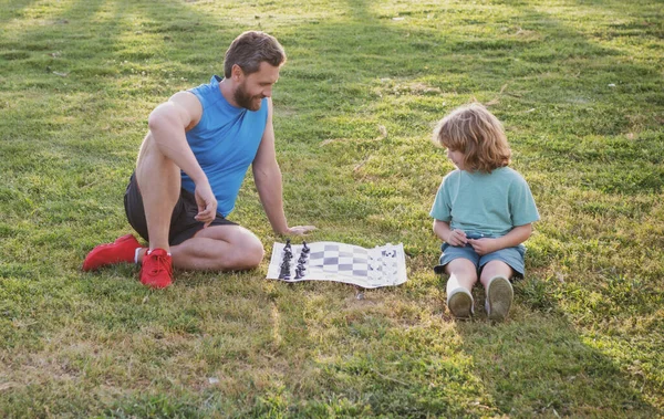 Father and son, little boy playing chess spending time together outdoor in summer park. — Stock Photo, Image