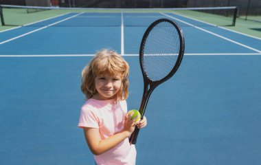 Tenis kortunda komik bir tenis oyuncusu. Tenis raketi ve tenis topları olan çocuk..