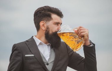 Sakallı barmenin profil portresi bira içiyor. Hippi adam bira içiyor..