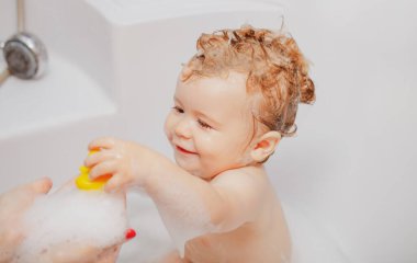 Banyo yapan bebek. Kafasında köpük olan mutlu çocuk. Çocuk köpük banyosu.