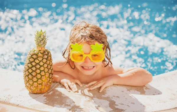 Chlapec dítě šťastný koupání v bazénu. Malé dítě se baví v bazénu. Letní ananas ovoce. — Stock fotografie