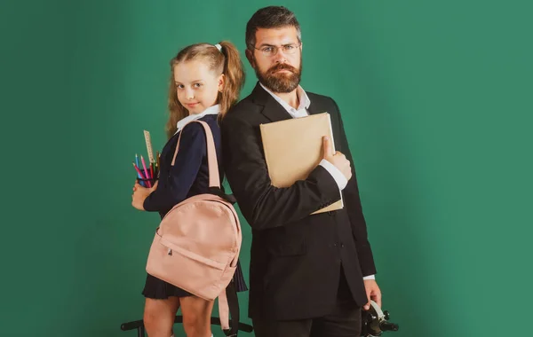 Zurück zur Schule, Schülerin mit Uniform. Vater oder Lehrer und kleines Schulmädchen in der ersten Klasse. — Stockfoto