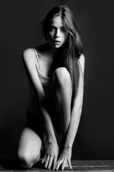 Snygg sexig kvinna på en grå bakgrund. Sensuell ung modell på svart studio. Ung modellflicka med smal kropp. Mode porträtt av elegant kvinna. — Stockfoto