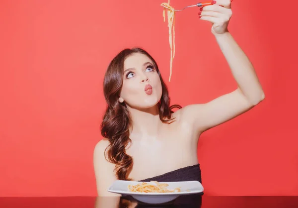 Flickan äter italiensk pasta med tomatsås. Kvinna med spaghetti. Bolognese vind runt gaffel. Parmesanost. — Stockfoto