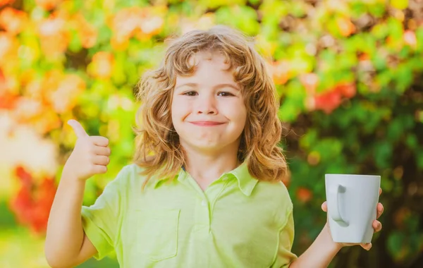 Retrato de crianças bonito com caneca, criança segurando uma grande xícara com chá de ervas. Infância feliz. — Fotografia de Stock