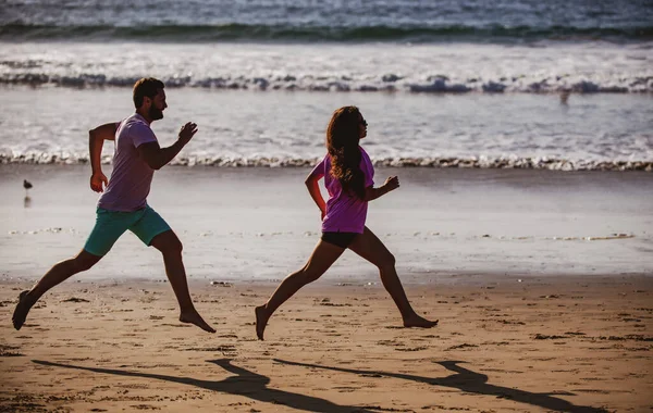 Jeune homme et jeune femme courant le long de la mer. Couple courant sur la plage. — Photo