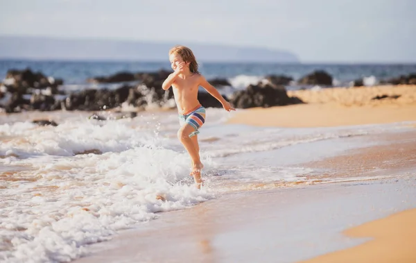 Deniz kıyısına yakın sularda koşan bir çocuk. Bir çocuk deniz kıyısında koşuyor. Çocukların geri kalanı yaz tatilinde.. — Stok fotoğraf