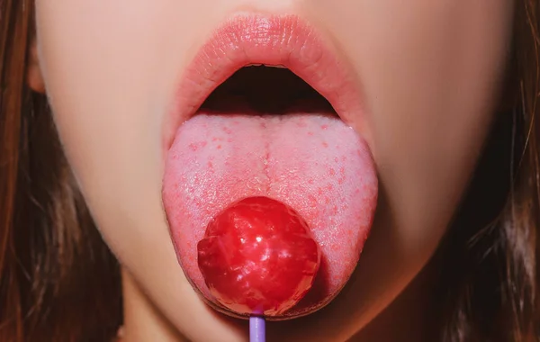 女性の口の中でロリポップ、赤い口紅。赤い光沢のあるロリポップを舐める女性。閉めろ。セクシー女性とともにロリポップでセクシー口. — ストック写真