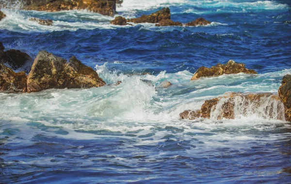 Meeressteinstrand, Wellen. Bunte blaue Meer Hintergrund. Das Konzept von Sommerurlaub und Reisen. Klares Meerwasser, große Steine am Strand. — Stockfoto