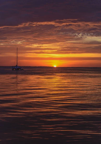 Barca sull'oceano al tramonto. Barche a vela con vele. Yacht di mare che naviga lungo l'acqua. — Foto Stock