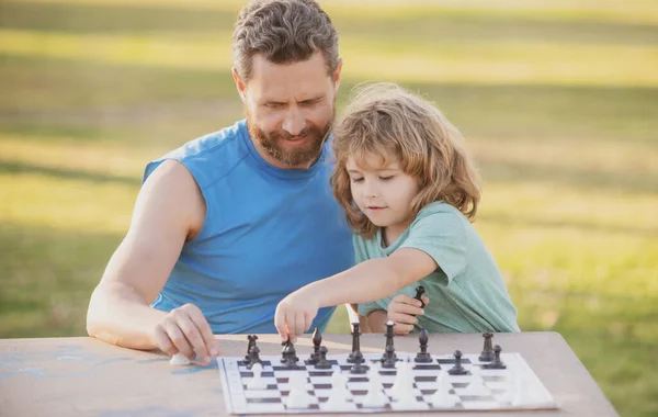 Il ragazzo gioca a scacchi. Padre e figlio giocano a scacchi. Festa dei Padri, famiglia dell'amore, genitorialità, concetto di infanzia. — Foto Stock