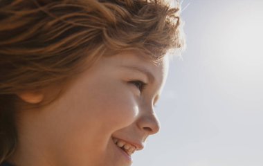 Küçük sarışın bir çocuğun portresi, yakın plan. Sevimli mutlu çocuk profili. Pozitif duygusal çocuk. Gülümseyen çocuklar..