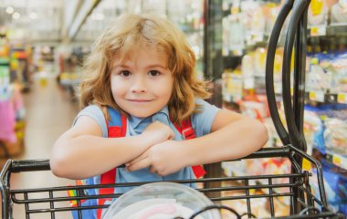 Markette alışveriş arabası olan bir çocuk..