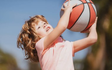 Parkta basketbol oynayan mutlu küçük çocuk. Çocuklar için spor.