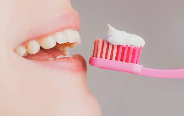 Cuidados dentários de perto. Mulher a escovar os dentes. Close-up em feliz jovem escovação dentes. — Fotografia de Stock