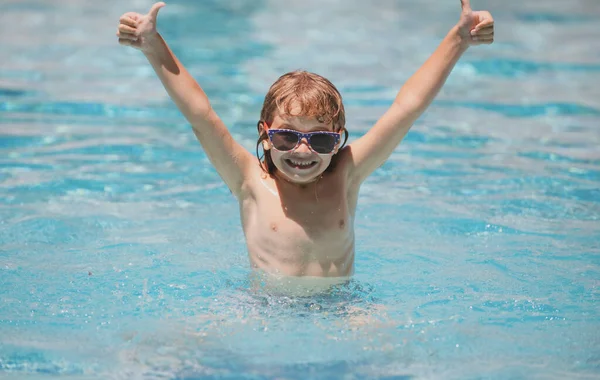 Niño lindo levantó las manos nadar en la piscina, fondo de agua de verano con espacio para copiar. Cara divertida de los niños. —  Fotos de Stock