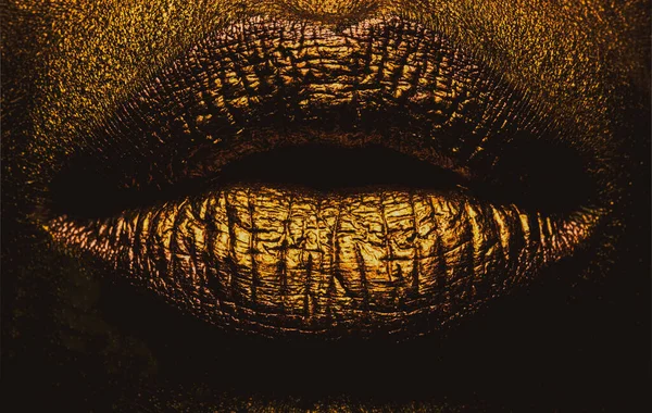 Closeup golden lips closeup. Gold metal lip. Beautiful makeup. Golden lip gloss on beauty female mouth, closeup. Sensual forms of woman lips. — Stock Photo, Image