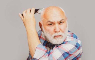 Gri son sınıf saç kesimleri. Kel yaşlı adam saç kesicisi, olgun kellik ve saç dökülmesi konsepti.