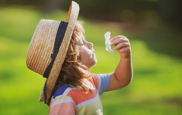 Ritratto bambino caucasico da vicino. Bambini in cappello di paglia profumato fiore di plumeria nel parco naturale estivo. — Foto Stock