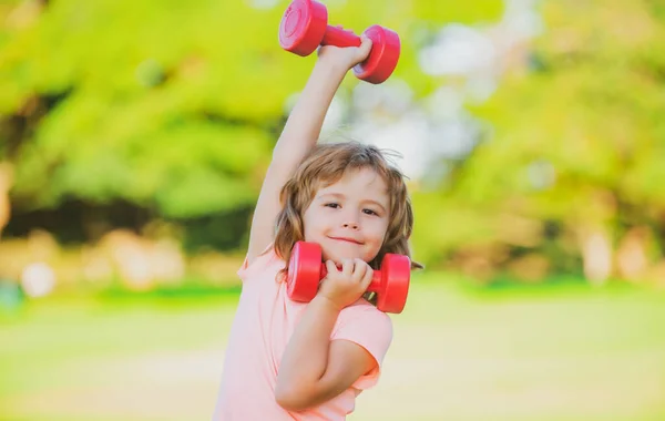 Dambılı bir çocuk. Çocuklar spor yapar. Çocuk parkta egzersiz yapıyor. Aktif, sağlıklı yaşam tarzı. — Stok fotoğraf