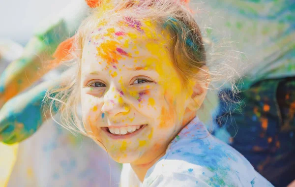 Festival de holi infantil. Cara pintada de chico gracioso. Niño juega con los colores. —  Fotos de Stock