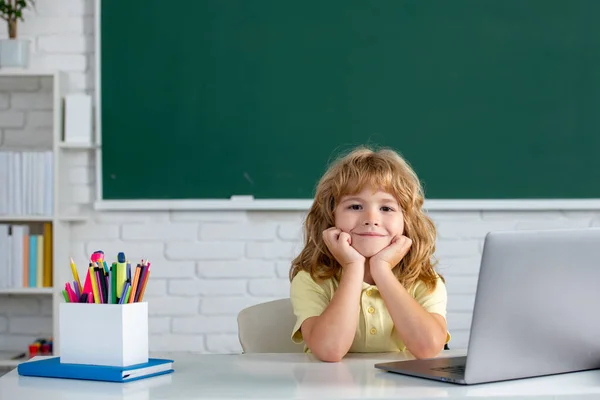 Leuke kleine schooljongen studeert in een klaslokaal. Online leertechnologie. — Stockfoto
