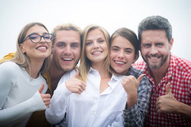 Gülümseyen bir grup arkadaş başparmağıyla gülüyorlar. Mutlu şirket öğrencileri selfie çeken en iyi arkadaşlar. Genç insanları bir araya toplayın genç arkadaşlar birlikte poz verin.