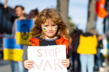 Child boy with poster with banner of russia conflict, military protest. America stand with Ukraine. Child with message Stop War. No war with Ukraine. clipart