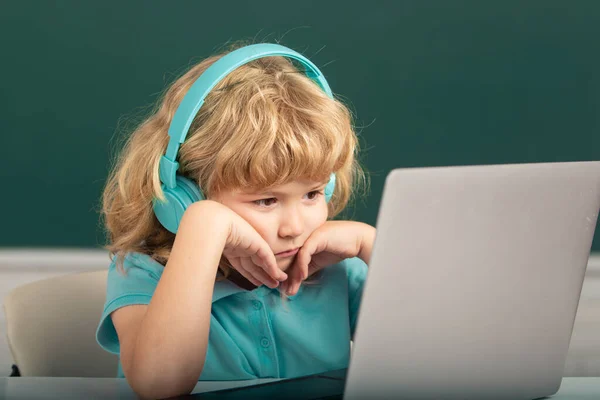 Serieuze jongen student leren online in de klas. Kind bestudeert online videogesprek met zoom. Leerling kind leren Engels taal online met laptop op school. — Stockfoto