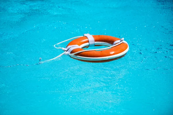 Drowning in water catch lifebuoy. Safety and urgent help. Resque needed. Life buoy floating in pool.