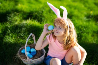 Paskalya yumurtası avlayan çocuk. Paskalya yumurtası ve tavşan kulaklı çocuk. Paskalya sepeti