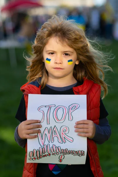 Menino jovem segurando um pôster com Stop mensagem de guerra, ativismo e movimento pelos direitos humanos, estilo de vida ao ar livre. — Fotografia de Stock