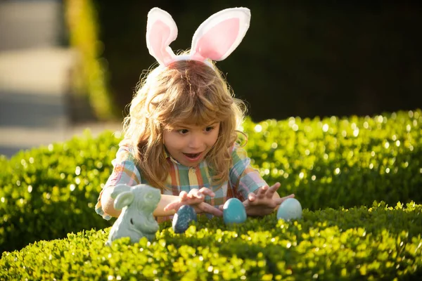 Feliz día de Pascua. Niños con orejas de conejo celebrando la Pascua. Niño niño cazando huevos de Pascua. —  Fotos de Stock