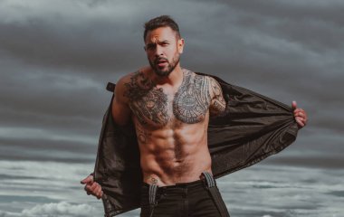 Kendine güvenen, çekici, seksi adam. Deri ceketli, modacı erkek model..