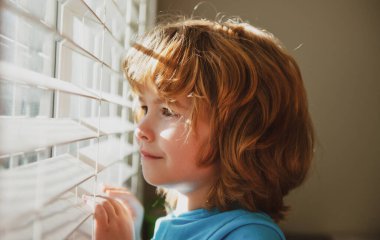 Karantina konsepti. Koru kendini. Evde tek başına kal. COVID-19 tecrit. Pencereden bakan çocuk. Koronavirüs salgını.